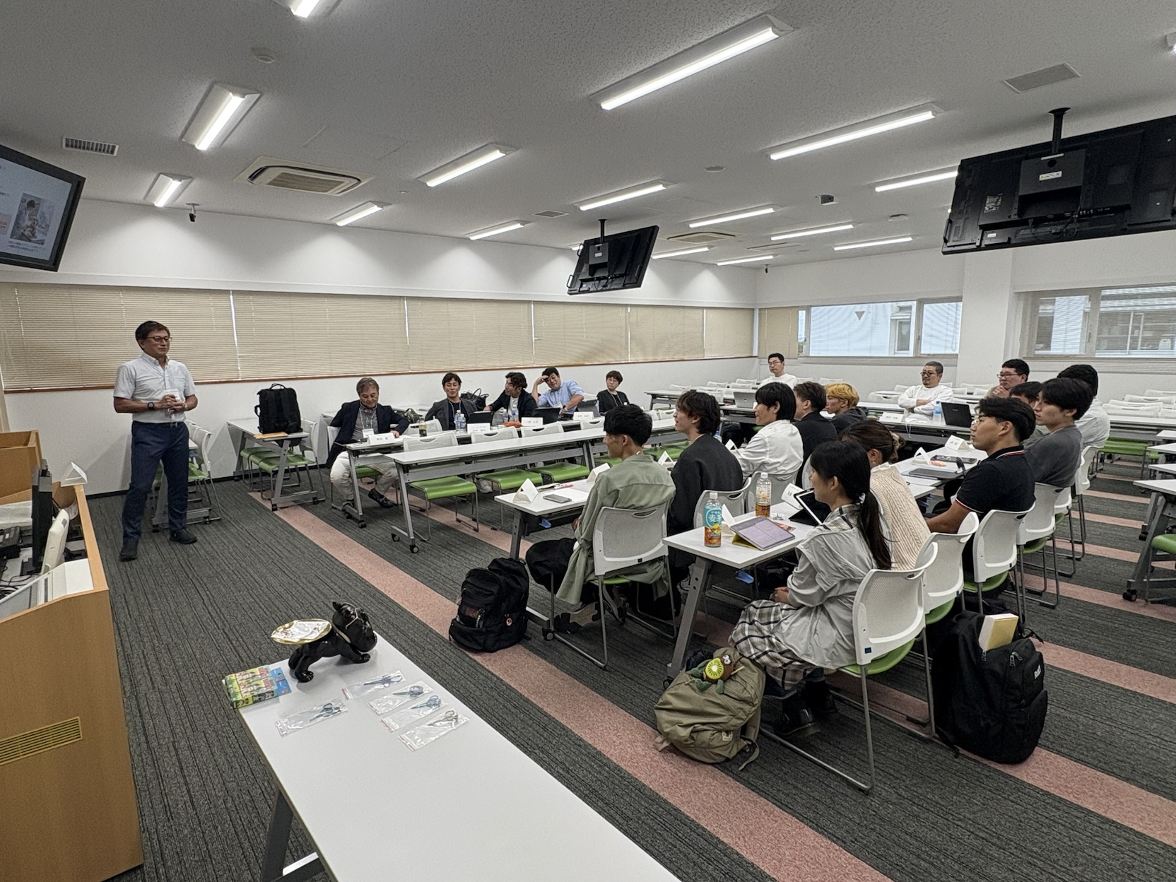 過去の勉強会で、講師を囲むように参加者が着席している会場全体の様子