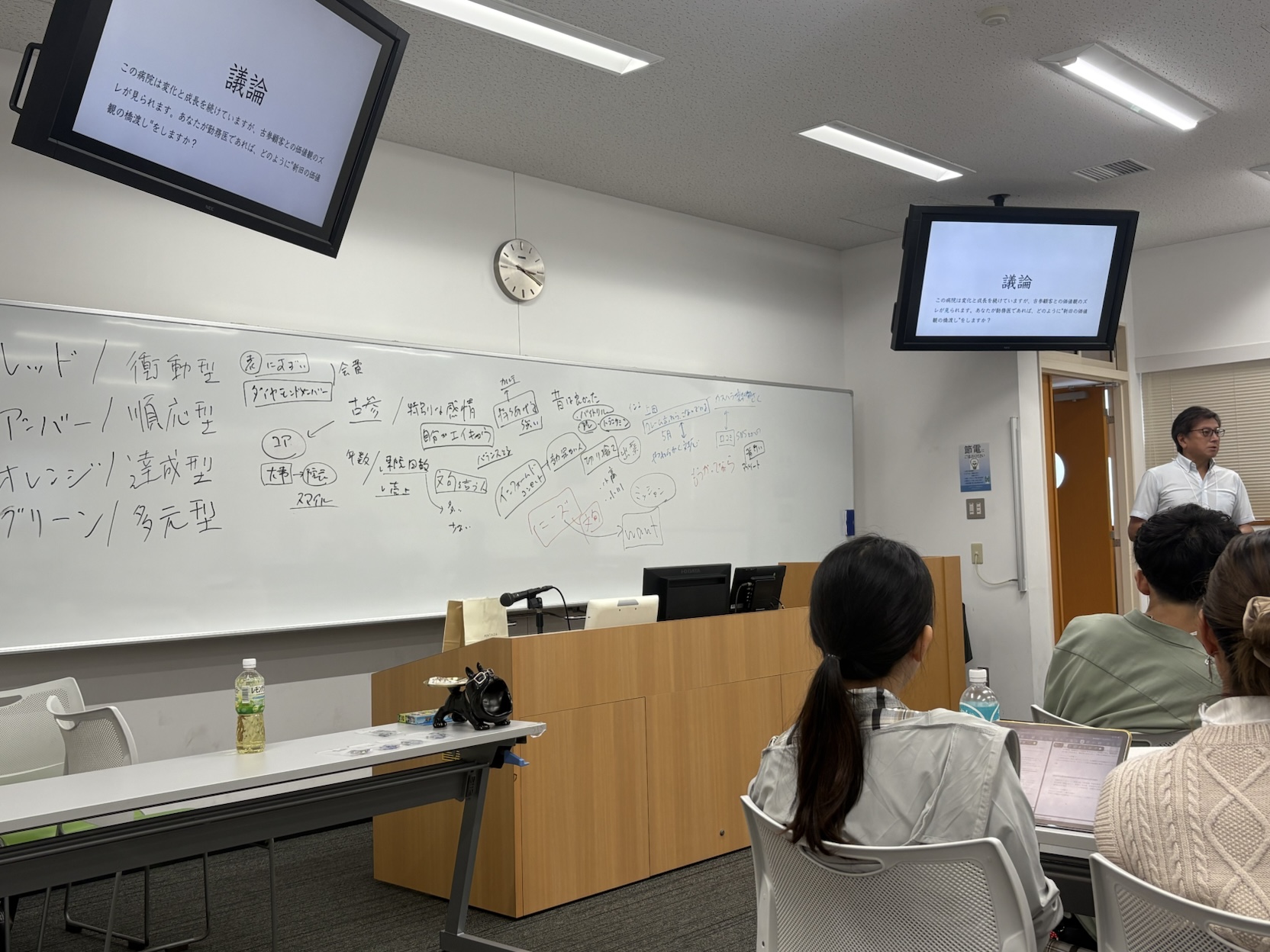 過去の勉強会で、ホワイトボードと資料を使って説明している様子