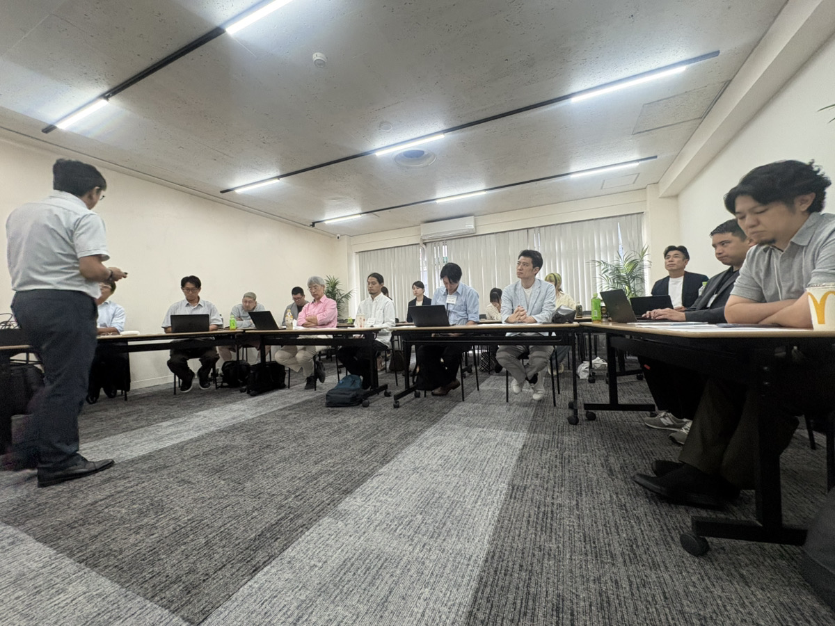 参加者が机を囲み、講義と対話に参加している様子